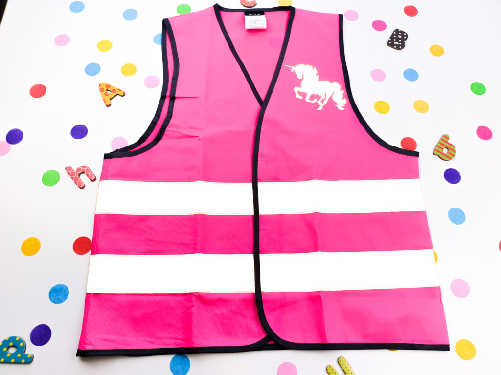 Kinder-Warnweste/Sicherheitsweste/Reflektorweste in pink, blau, und gelb mit personalisierten Motiven darunter.
